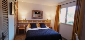 Un dormitorio con una cama y un espejo y una ventana. en Villa Le Lagon - Vision Luxe, en Bonifacio