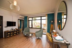 a living room with a table and chairs and a mirror at Lovely Flat with Balcony near Hadrian's Gate in Antalya