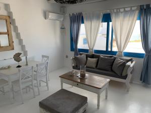 uma sala de estar com um sofá e uma mesa em Blue Sea Villa & Apartments em Makry Gialos