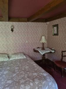 a bedroom with a bed and a table and a lamp at Appartement spacieux tout confort in Les Rousses