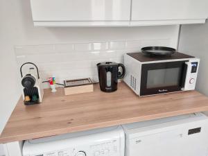 un piano di lavoro con un forno a microonde e una tazza da caffè di Le Mistralet a Salon-de-Provence