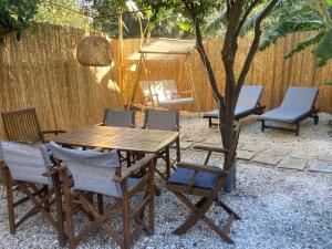 a wooden table and chairs with a tree and a fence at Evis House in Chania Town