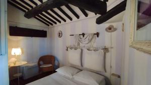 um quarto com uma cama, uma mesa e um candeeiro em Le Residenze Ristori em Cortona