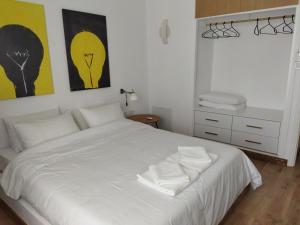 a bedroom with a white bed with two white pillows at Minimal apartment by the beach in Korinthos