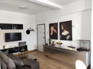 a living room with a couch and a tv at Minimal apartment by the beach in Korinthos