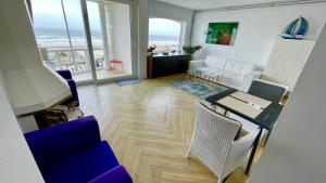 a living room with a couch and a table and chairs at Beach Apartments Seaview Plus Parking in Zandvoort