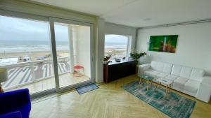 a living room with a couch and a view of the ocean at Beach Apartments Seaview Plus Parking in Zandvoort