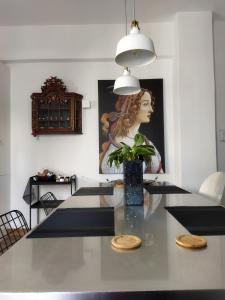 a dining room with a table with a vase with a plant at Minimal apartment by the beach in Korinthos