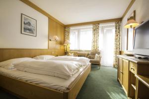 um quarto de hotel com uma cama e uma televisão em Haus Patricia em Lofer
