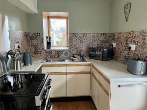a kitchen with a sink and a stove top oven at Joyces Cottage, 2 Brown Hill in Richmond
