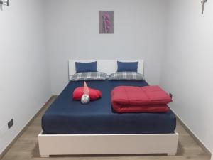 a bed with red and blue sheets and pillows at Villa Nonno Nicola in Montenero di Bisaccia