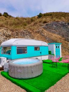 a rv parked next to a table and a patio at Tropical Dreams Motril in Los Tablones