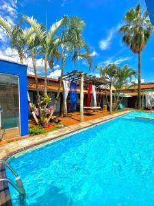 una piscina frente a una casa con palmeras en O Sole Mio - Hotel Pousada, en Planura