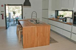 a kitchen with a wooden island in the middle at Casa Do Guarda Rios in Ponte Nova