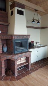 a kitchen with a brick fireplace with a sink at VilaFėja Private courtyard house in Palanga