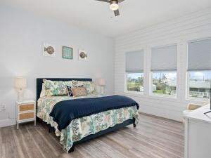 - une chambre blanche avec un lit et 2 fenêtres dans l'établissement Circle P Coastal, à Rockport