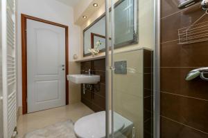 e bagno con servizi igienici, lavandino e doccia. di Apartments Villa White House a Omiš (Almissa)