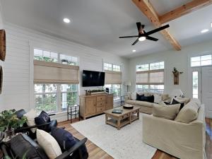 Una sala de estar con un sofá y un ventilador de techo. en Wood Beach Retreat, en Santa Rosa Beach