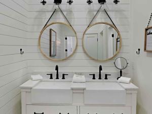 un baño con dos lavabos y dos espejos en Wood Beach Retreat, en Santa Rosa Beach 17 fotos más