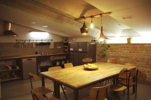 a kitchen with a wooden table with a bowl of fruit on it at GARAGE HOSTEL in Nova Gorica