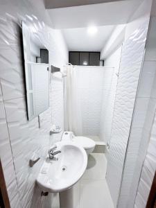 a white bathroom with a sink and a mirror at Huascarán Inn in Mancos