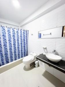 Baño blanco con aseo y lavamanos en Huascarán Inn, en Mancos