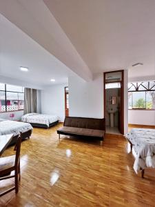 Cette grande chambre comprend deux lits et un canapé. dans l'établissement Huascarán Inn, à Mancos