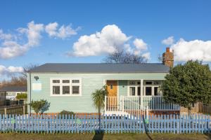 a green house behind a white fence at Den of Joy Humberston Fitties sleeps 6,hot tub,log burner in Cleethorpes