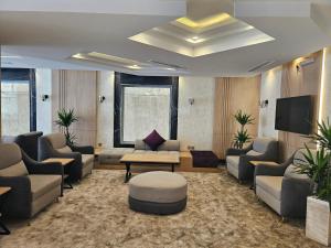 a lobby with a waiting room with couches and a tv at فندق زوايا الماسية فرع الحزام in Al Madinah