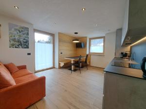 a kitchen and living room with a couch and a table at Bait da Pemont in Livigno