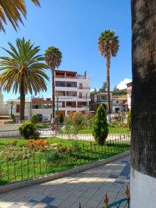 a park with palm trees and a building at Huascarán Inn in Mancos