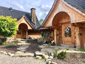 a large wooden house with a stone path in front of it at GORSKA OSADA Lovely Chalets Zakopane in Poronin