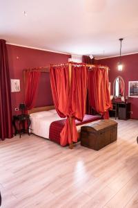 a bedroom with red walls and a bed with red curtains at Binario Magic RistoHotel in Palazzago
