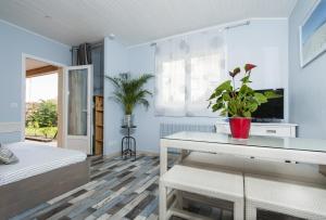 um quarto com uma cama e uma mesa com um vaso de plantas em Le Studio de Noreda em Gujan-Mestras