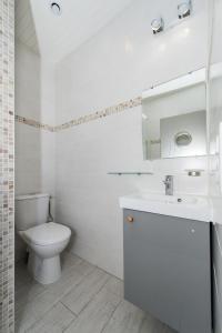 a white bathroom with a toilet and a sink at Le Studio de Noreda in Gujan-Mestras