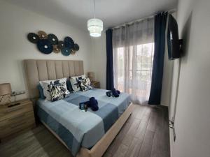 1 dormitorio con cama con sábanas azules y ventana en Ohana home beach and love, en Caleta de Fuste