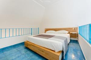 Schlafzimmer mit einem Bett und blauen Fliesenböden in der Unterkunft La Dependance - Gioia Apartments in Procida