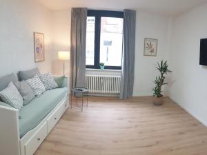 a living room with a couch and a window at Studio Apartments in Ruhrgebiet in Mülheim an der Ruhr