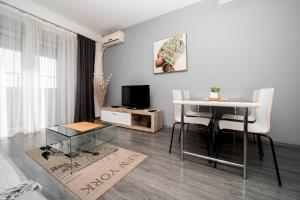 a living room with a table and a television at Ring Inn Apartments in Obrenovac