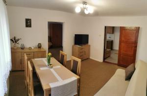 a living room with a dining table and a television at Dom Na Zachodzie in Szczecinek
