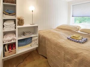 ein Schlafzimmer mit einem Bett und Regalen mit Handtüchern in der Unterkunft Holiday home Åsenfjord 