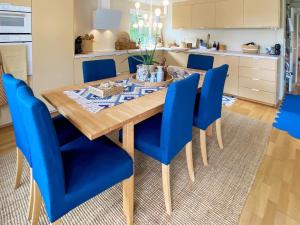 a dining room with a wooden table and blue chairs at Holiday home Åsenfjord 