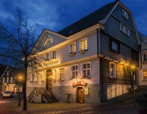 a large white building with lights on it at night at Elektro-Hotel Rosenhaus GmbH in Velbert