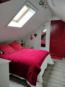 een slaapkamer met een rood bed en een rode deken bij La tiote glaine in Cappelle-en-Pévèle