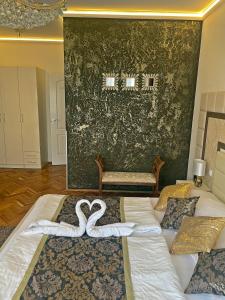 a bedroom with two swans in the middle of a bed at Melior Szálló in Eger