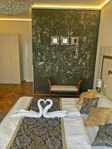 un dormitorio con dos cisnes en medio de una cama en Melior Szálló, en Eger
