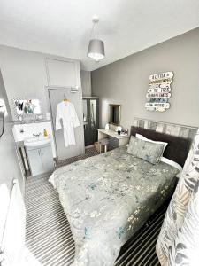 a bedroom with a bed and a dresser and a mirror at Belle Dene Guest House in Paignton