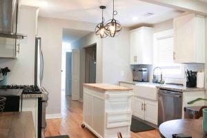 eine Küche mit weißen Schränken und einem Kronleuchter in der Unterkunft 3BR Lovely Furnished Westside Home with amenities in Atlanta
