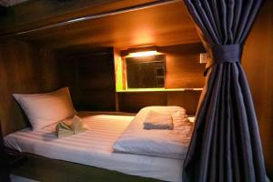 a bed in a room with a curtain at Bui Vien Street Hostel in Ho Chi Minh City