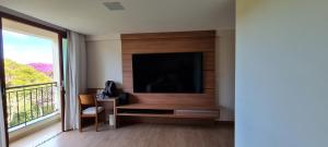 a living room with a flat screen tv on a wall at Vista para Pedra Azul e TV de 85'' in Pedra Azul
